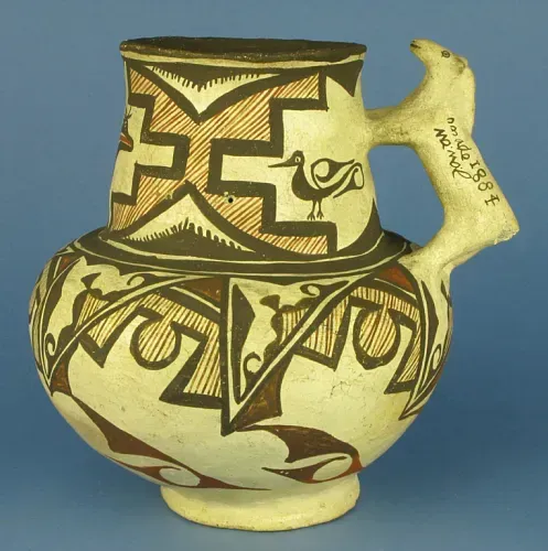 Pottery jug with horse-shaped handle and abstract birds and patterns in brown, burgundy-red, dark brown against cream. It is round at the bottom with a tall cylindrical top and narrow base.