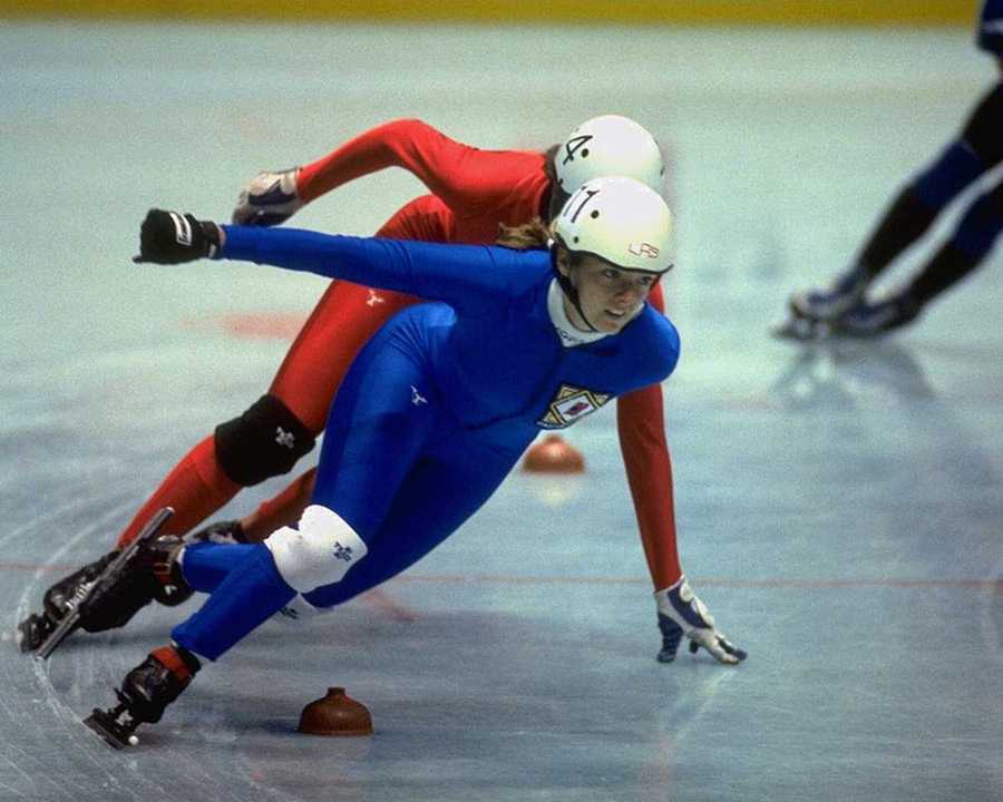Two female speed skaters taking a corner.