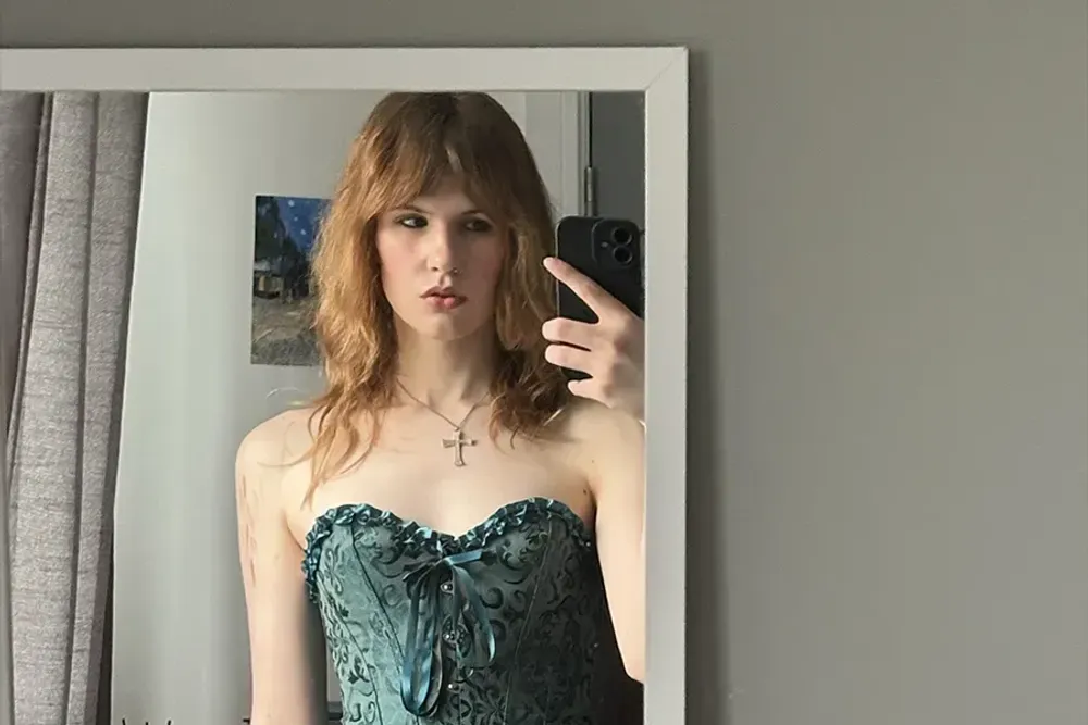 A photo of, poet, Lyra Button wearing a long black skirt and a corset.