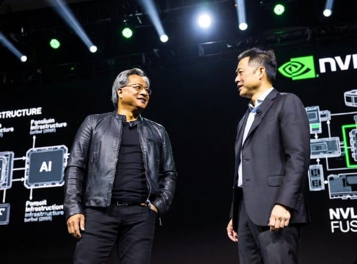 Two men standing on stage in front of a screen with Nvidia logos and AI infrastructure diagrams.