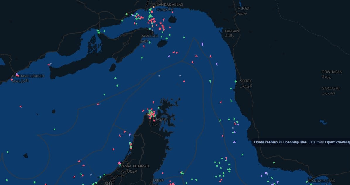 Map of Strait of Hormuz showing numerous colored ship icons across blue waters near Bandar Abbas, Ras Al Khaimah and other ports.