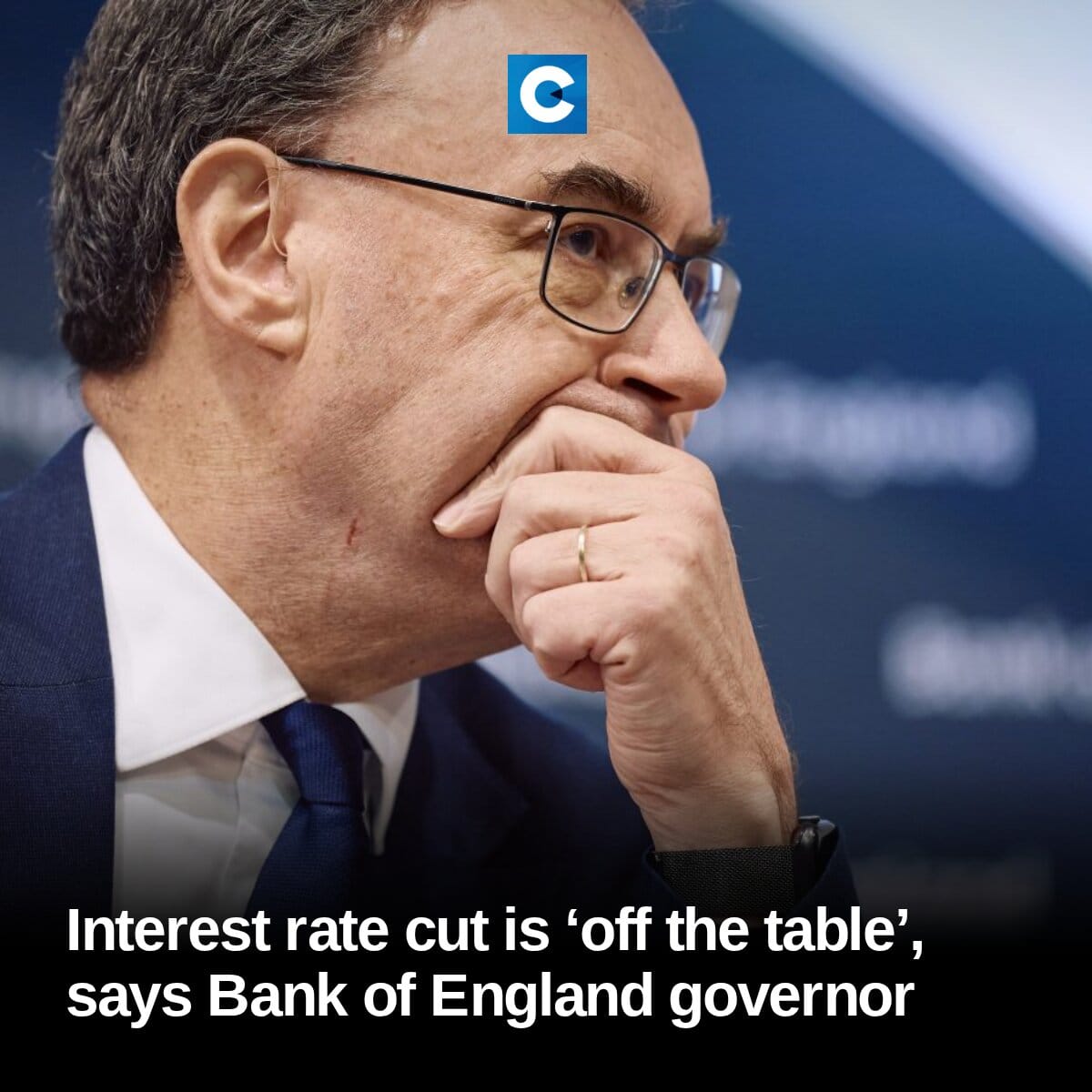 Close-up photo of Bank of England Governor Andrew Bailey in a suit and glasses, hand near his chin.