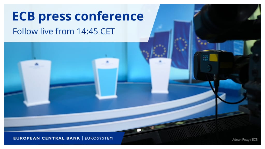 Empty white podiums on a blue ECB press-conference stage with EU flags and a TV camera in the foreground.