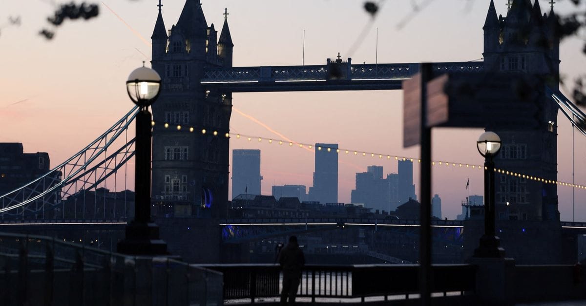 Tower Bridge in London at dusk, with string lights, street lamps, a riverside walkway, and a person in silhouette.